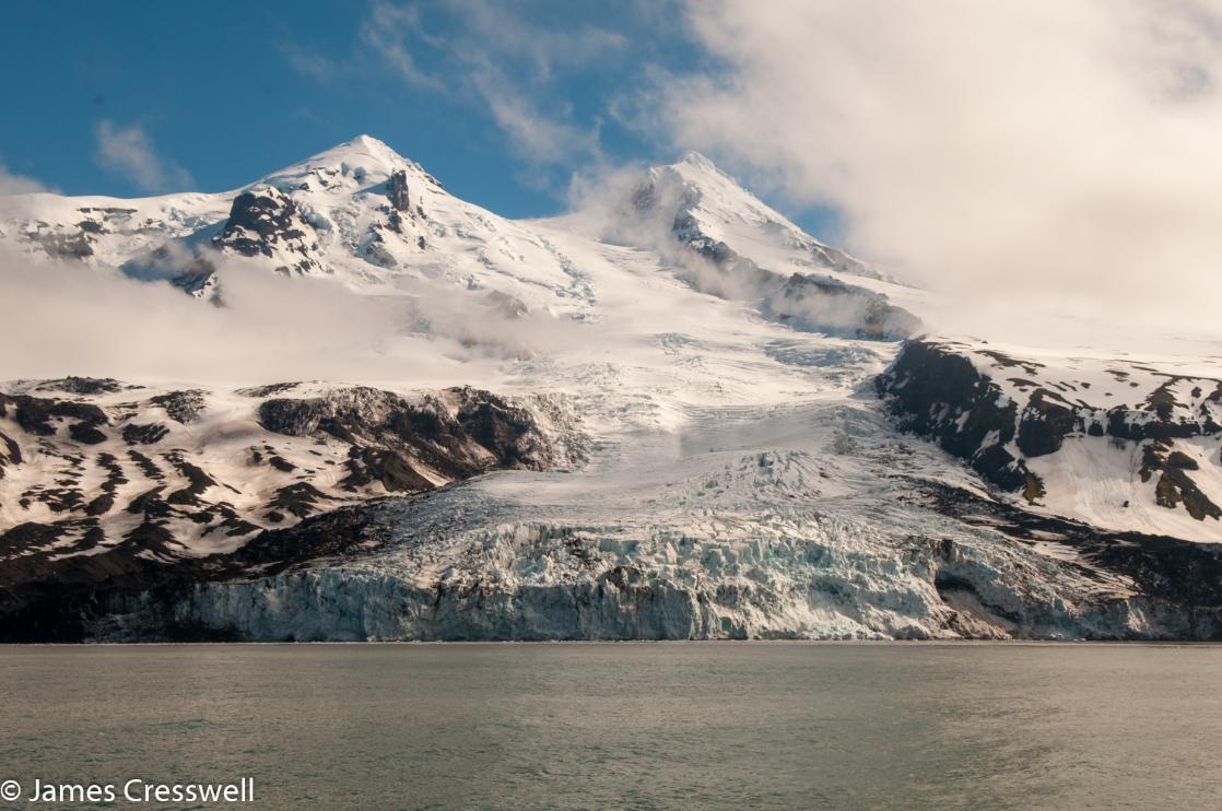 A photograph of a glacier flowing from the summit of Beerenberg volcano to the sea on Jan Mayen, taken on a PolarWorld Travel placed expedition cruise