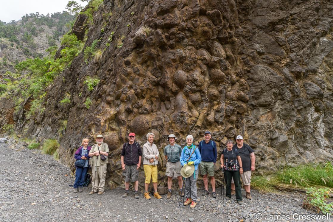 A photograph a GeoWorld Travel group in the Barranco de las Angustias with spectacular pillow basalts behind. 