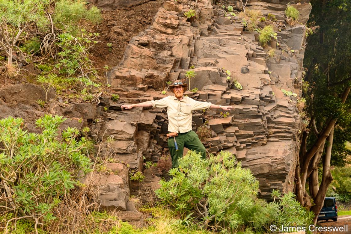 A photograph of James Cresswell from GeoWorld Travel standing on a massive dyke on La Gomera