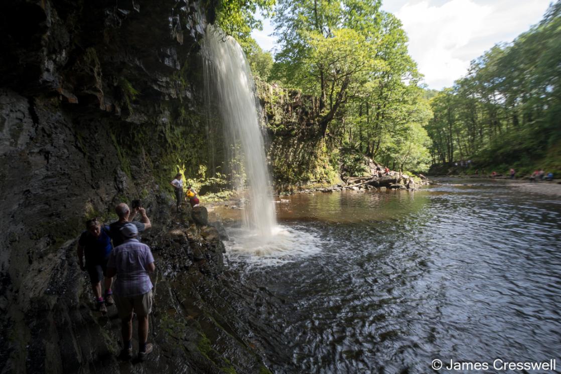 A photograph taken behind Sgwd Gwladys waterfall in the Bannau Brycheiniog National Park