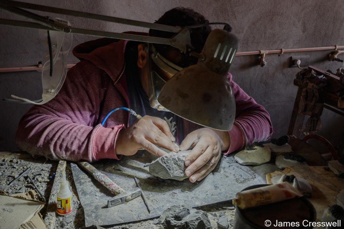 A photograph of a man preparing a trilobite in Morooco