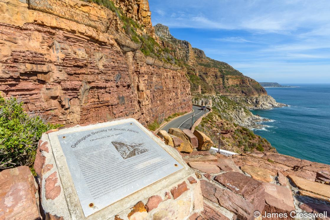 A photograph of the Geological Society of South Africa’s plaque on Chapman’s Peak Drive, on the Cape Peninsula. Here the Ordovician aged sedimentary rocks of the Table Mountain Group (reddish colour) sit unconformably on the Cambrian aged Cape granite (grey colour).
